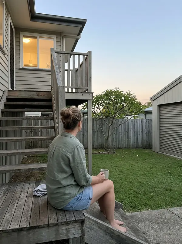 Erin sits on her back steps with a cup of tea just after sunset.