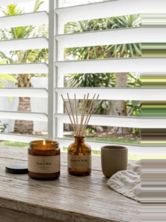 A candle and a diffuser on a sunny windowsill