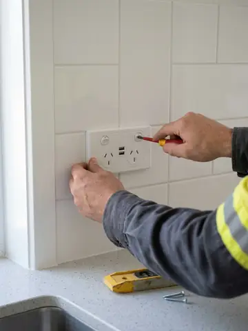 Hands fitting a new double power point with USB sockets